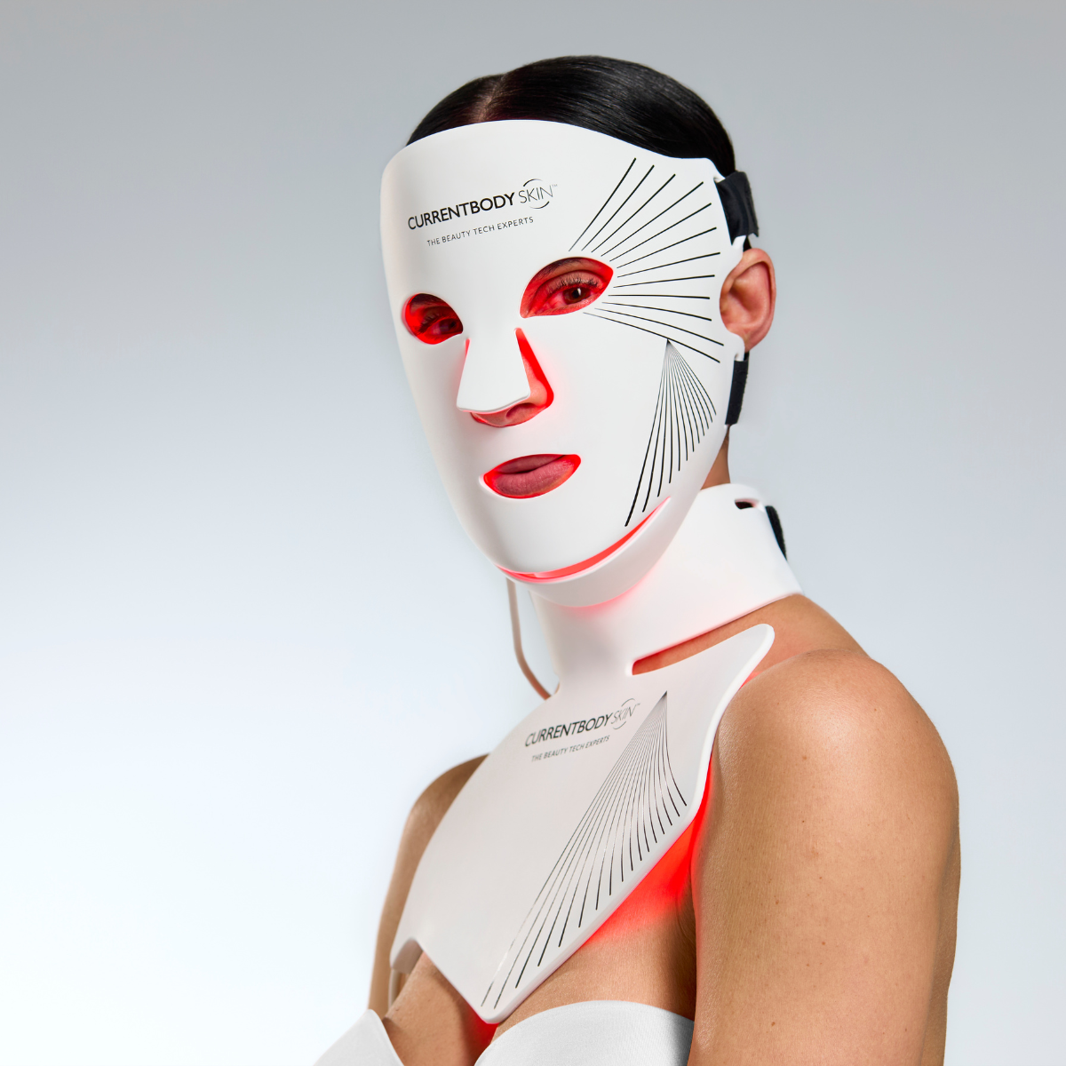 CurrentBody Skin LED red light therapy face mask on a model, showing its design for facial and neck skin treatment.