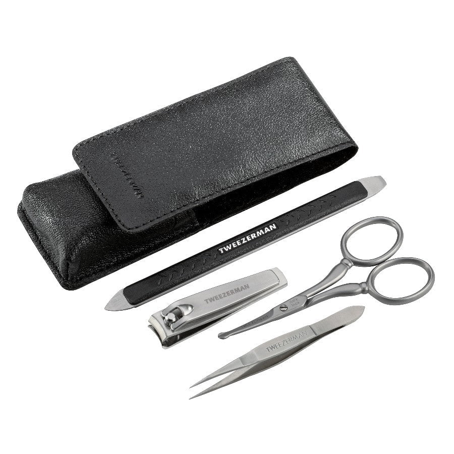 Tweezerman Essential Grooming Kit with nail clippers, tweezers, and scissors arranged in a compact case for personal grooming.