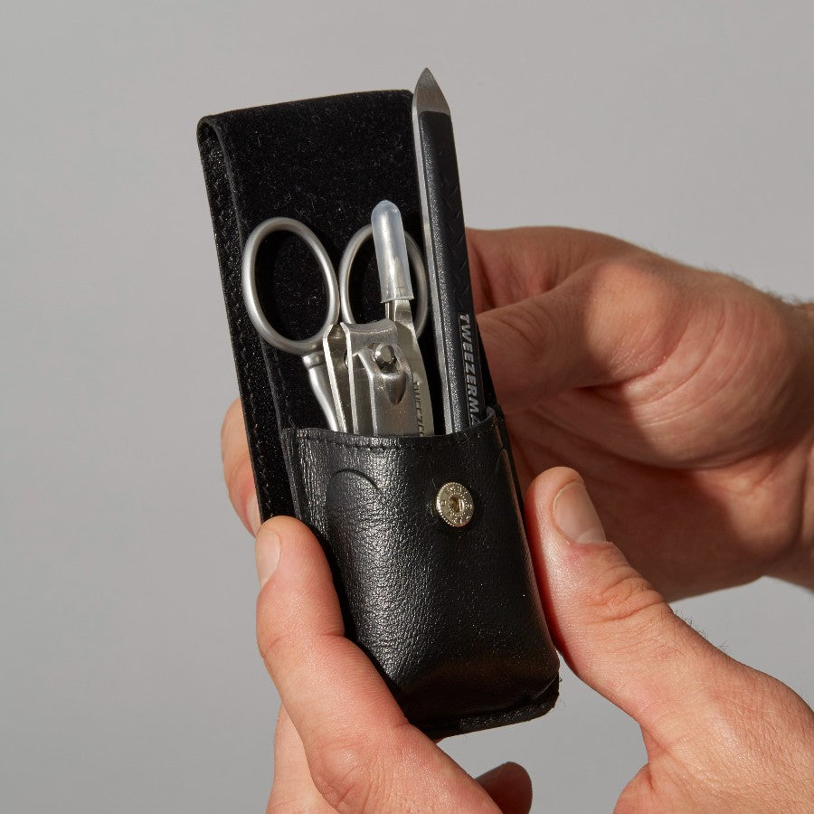 Tweezerman Essential Grooming Kit with precision tweezers, scissors, and nail tools arranged in a compact case.