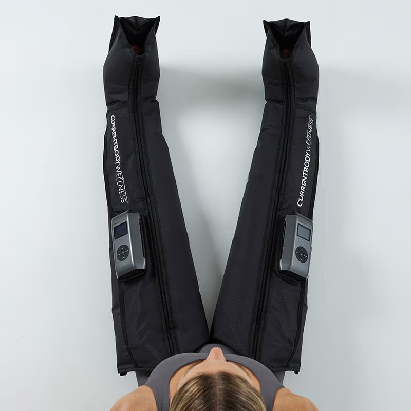 CurrentBody Skin wellness sauna blanket and recovery compression boots in a modern home setting, showcasing relaxation and therapy tools.