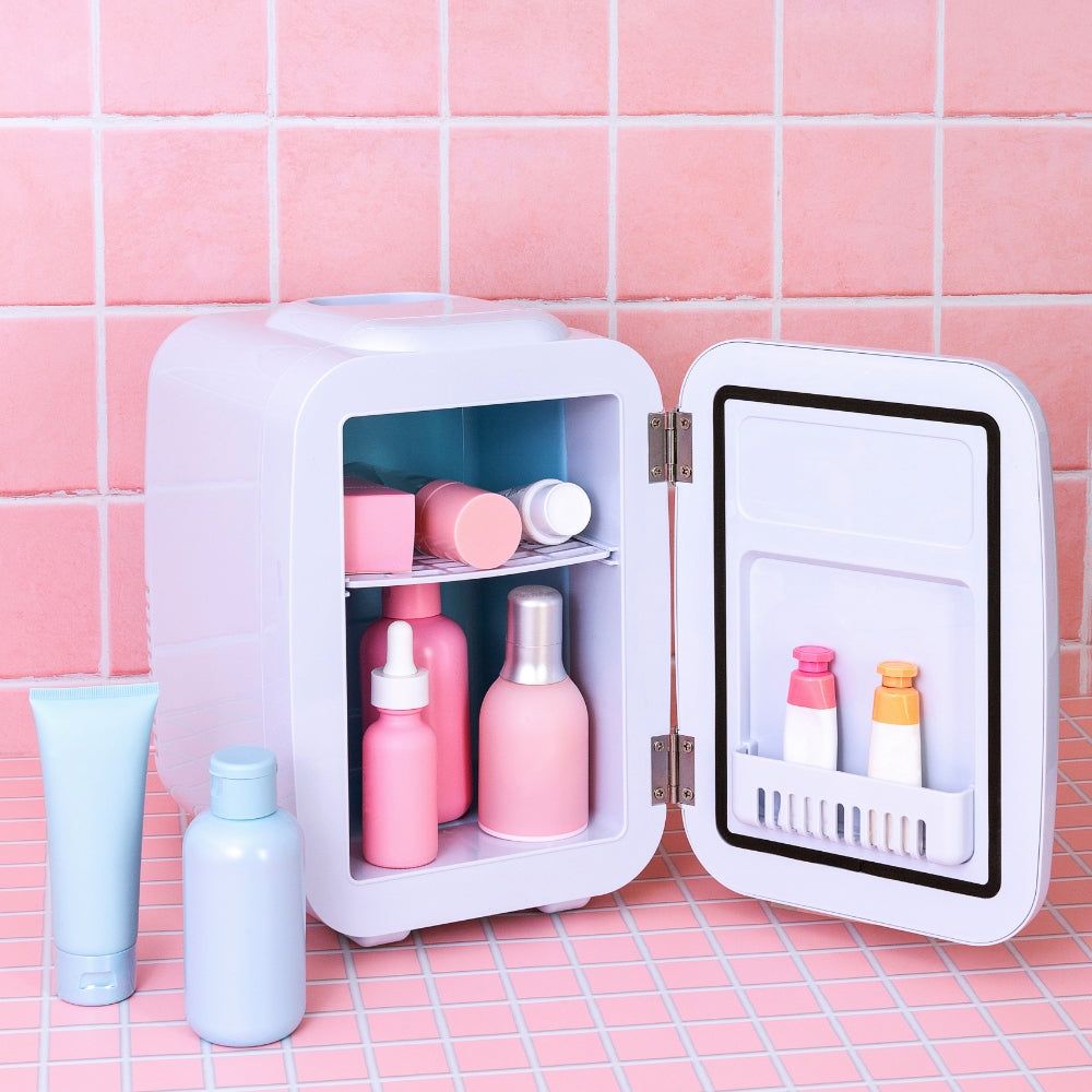 LEDMASKCONCEPT StylPro Beauty Fridge in elegant rose gold, compact design with clear door showcasing internal storage.